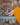 Person wearing orange sandals with a patterned wall and yellow fabric in the background